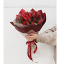 Весенний букет из 19 красных тюльпанов в стильном оформлении.